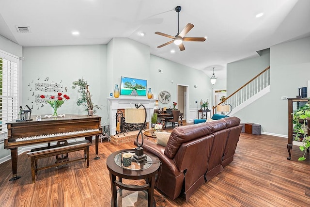 7731 Sleepy Lagoon Way, Flowery Branch, GA 30542 - living area with stairs, wood finished floors, a ceiling fan, a brick fireplace, and vaulted ceiling