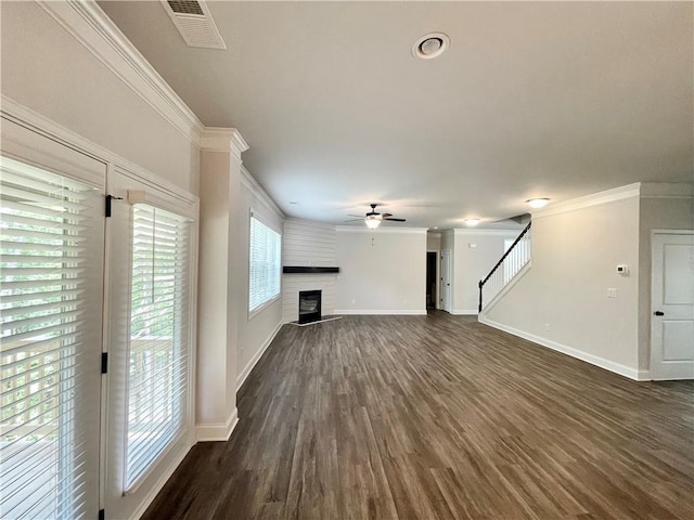 unfurnished living room with dark wood-type flooring, a fireplace, ornamental molding, and ceiling fan