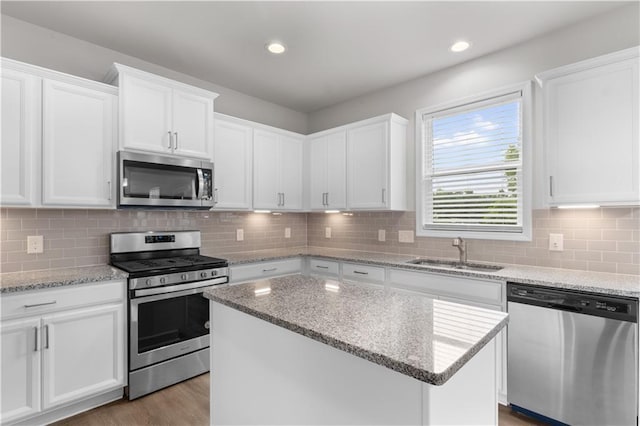 4238 Linworth Blvd, Austell, GA 30106 - kitchen with stainless steel appliances, a sink, white cabinetry, a center island, and decorative backsplash
