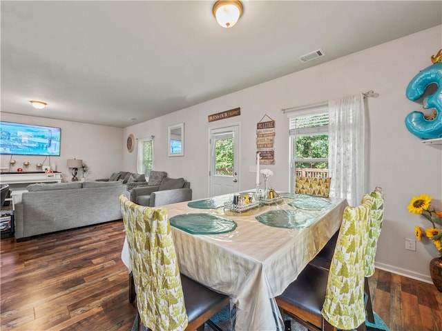 dining area featuring dark wood-type flooring and plenty of natural light