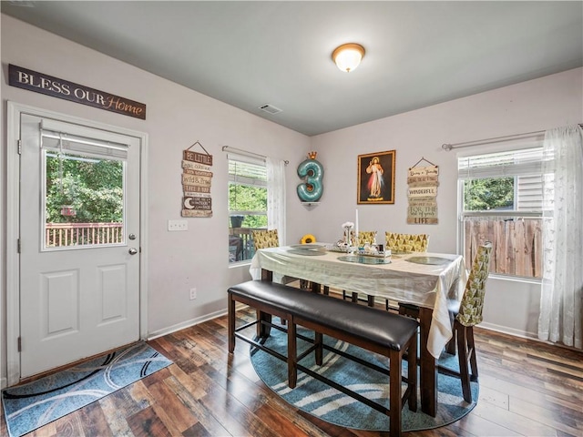 dining area featuring a wealth of natural light and dark wood-type flooring