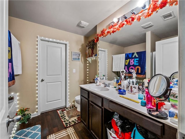 bathroom featuring vanity, hardwood / wood-style floors, and toilet