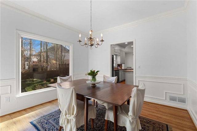 dining room with visible vents, plenty of natural light, and wood finished floors