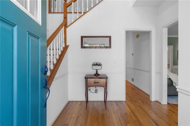 entrance foyer featuring stairway, wood finished floors, and baseboards