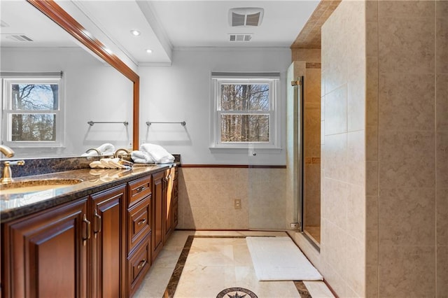 bathroom with a stall shower, visible vents, ornamental molding, tile walls, and recessed lighting