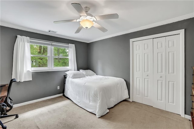 bedroom with carpet, a closet, visible vents, ornamental molding, and baseboards