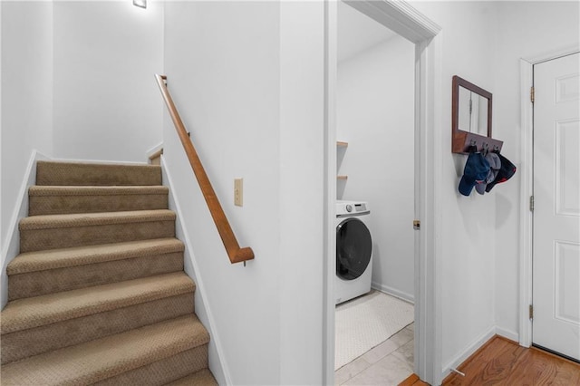 washroom with laundry area, wood finished floors, washer / dryer, and baseboards