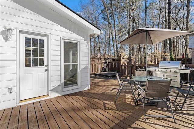 deck featuring outdoor dining space and grilling area