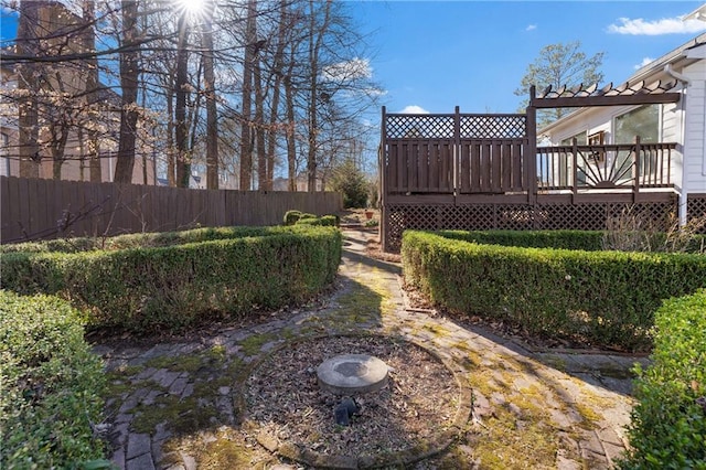 view of yard featuring fence and a deck