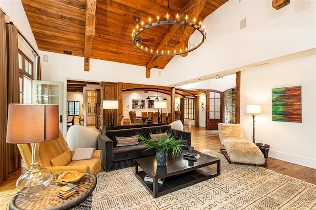 living area featuring baseboards, wood ceiling, wood finished floors, beamed ceiling, and high vaulted ceiling