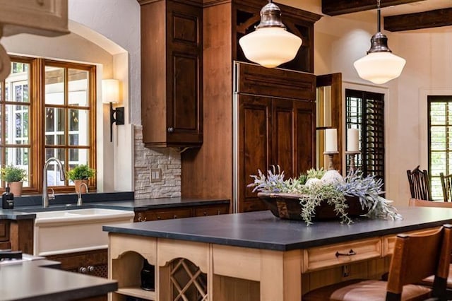 interior space with beamed ceiling, backsplash, and decorative light fixtures