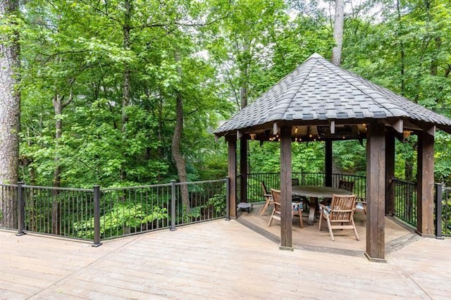 view of patio / terrace featuring outdoor dining space, a deck, and a gazebo
