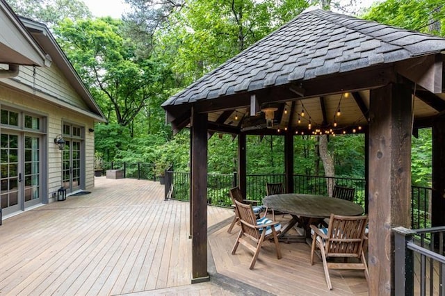 wooden deck with a gazebo, french doors, and outdoor dining area