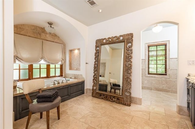 full bath featuring visible vents, a garden tub, and vanity