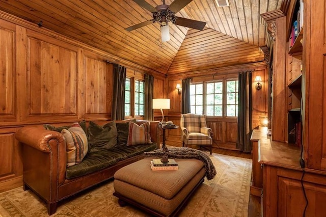 sitting room with lofted ceiling, wooden ceiling, ceiling fan, and wood walls