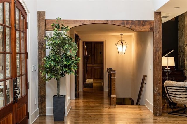 entryway featuring arched walkways and wood finished floors