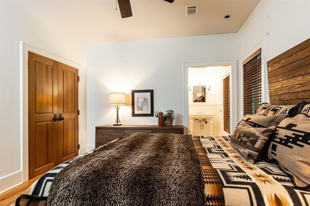 bedroom with a ceiling fan, visible vents, and ensuite bath