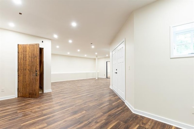 spare room with baseboards, dark wood-style flooring, and recessed lighting
