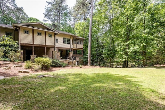 rear view of property featuring a lawn