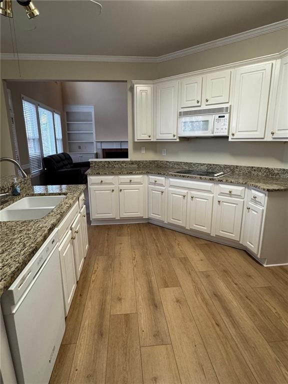 kitchen with sink, white appliances, white cabinets, and ornamental molding