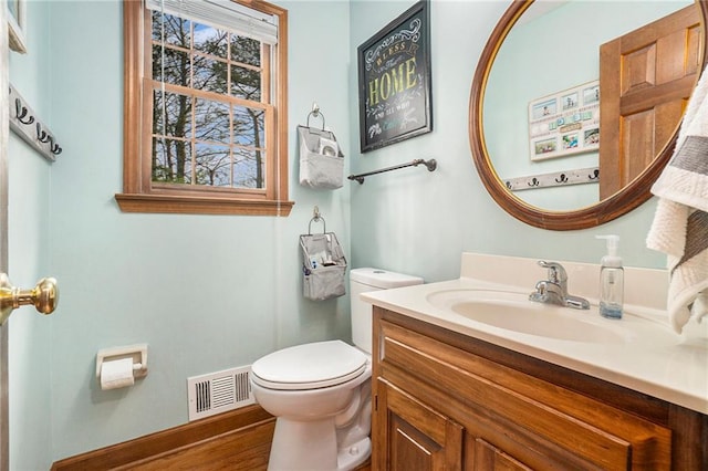 bathroom featuring vanity, wood-type flooring, a wealth of natural light, and toilet