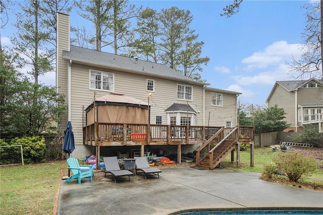 rear view of property with a gazebo, a yard, a deck, and a patio area