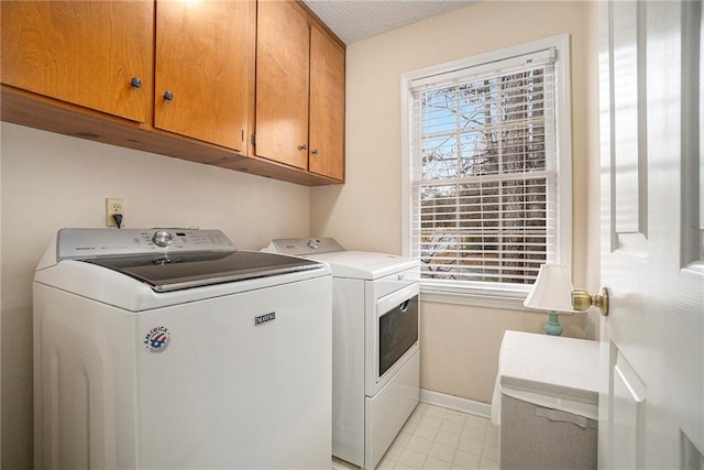 washroom with cabinets, plenty of natural light, and washing machine and clothes dryer