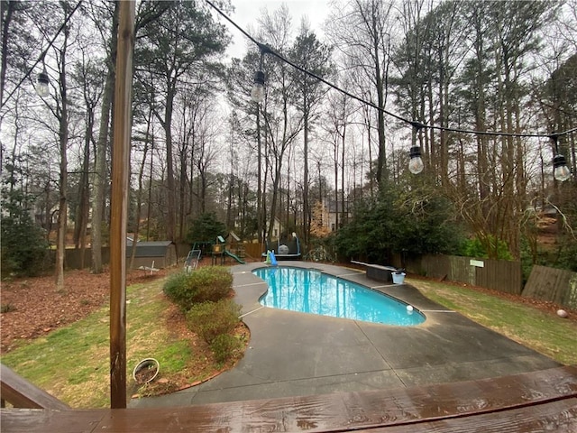 view of pool featuring a playground and a patio