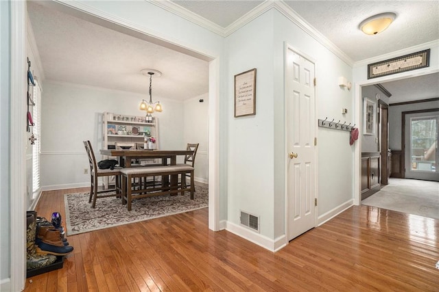 interior space with crown molding, a chandelier, hardwood / wood-style floors, and a textured ceiling