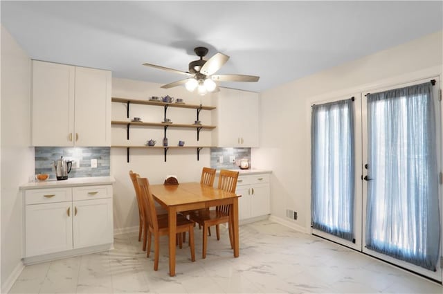 dining area featuring plenty of natural light, visible vents, baseboards, ceiling fan, and marble finish floor