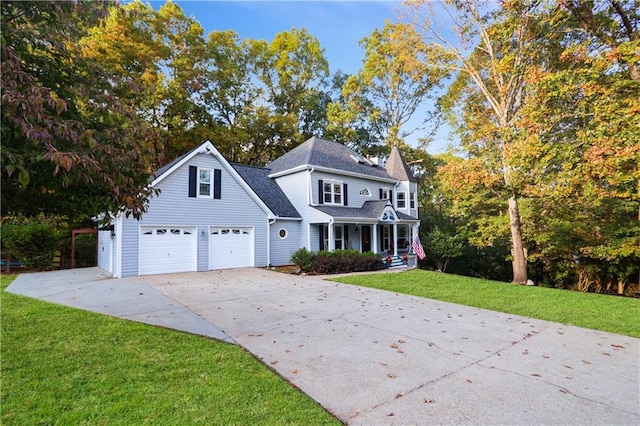 view of front of house featuring a garage, covered porch, concrete driveway, and a front yard