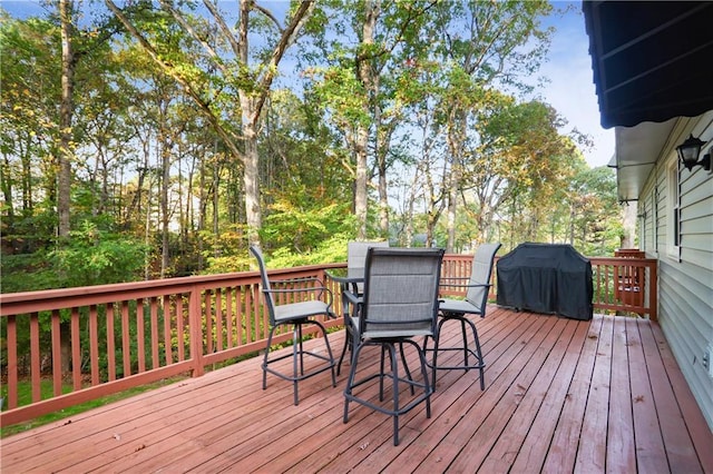 wooden terrace featuring outdoor dining area and a grill