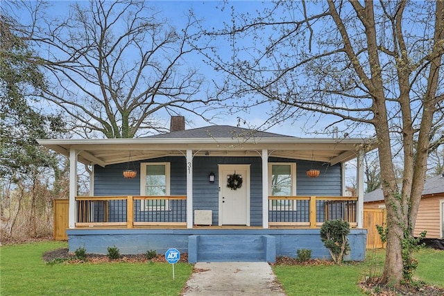 bungalow-style home with a front yard and covered porch