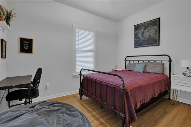 bedroom with wood-type flooring and multiple windows