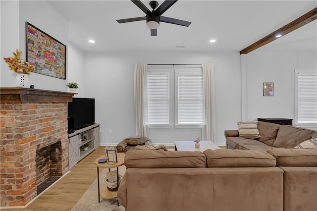 living room with ceiling fan, light hardwood / wood-style flooring, a fireplace, and a wealth of natural light