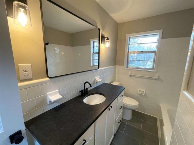 bathroom with tile patterned flooring, vanity, tile walls, and toilet