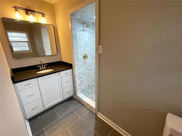 bathroom featuring vanity, tile patterned flooring, toilet, and tiled shower