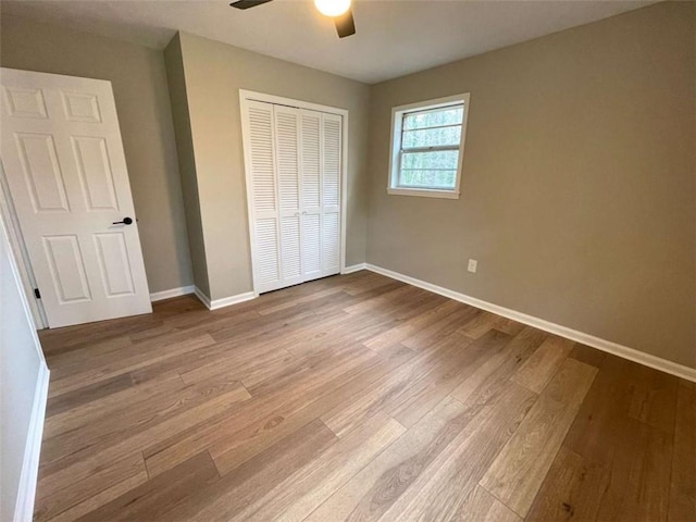 unfurnished bedroom with ceiling fan, a closet, and light hardwood / wood-style flooring