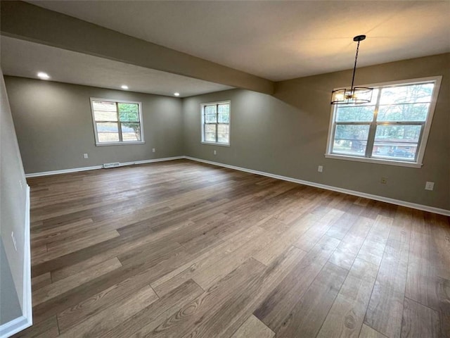 unfurnished room featuring wood-type flooring and a chandelier