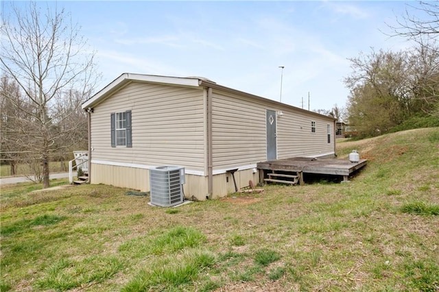 view of home's exterior featuring a lawn and central AC