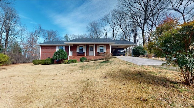 single story home with brick siding, concrete driveway, covered porch, a carport, and a front yard