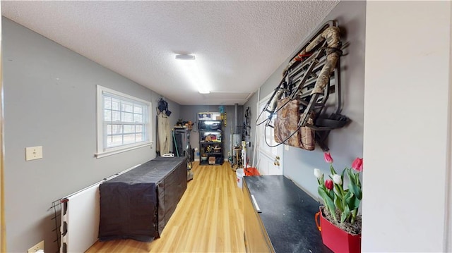 mudroom with light wood-type flooring and a textured ceiling