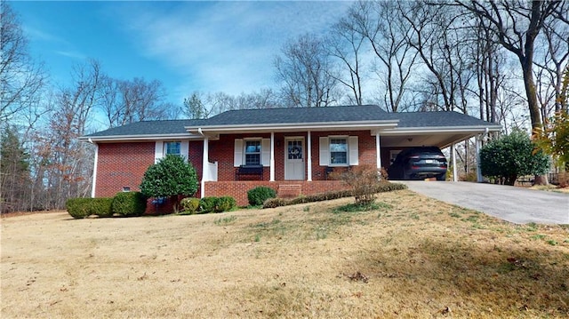 view of front of property featuring driveway, brick siding, a front yard, and an attached carport