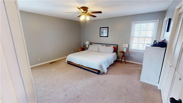 carpeted bedroom with ceiling fan and baseboards