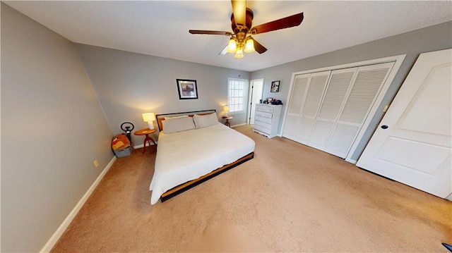 bedroom with light carpet, ceiling fan, a closet, and baseboards