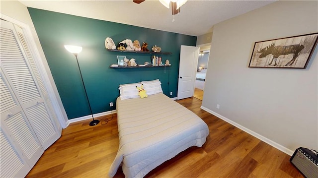 bedroom featuring a closet, baseboards, and wood finished floors