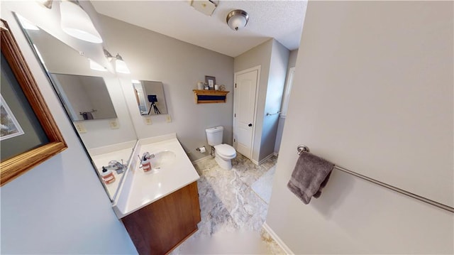 bathroom with baseboards, vanity, and toilet