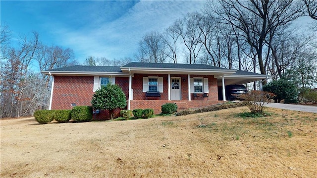 single story home featuring driveway, a carport, a front lawn, and brick siding