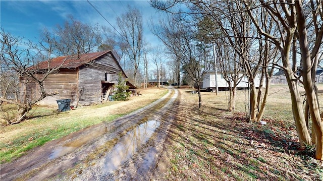 view of road with a barn and driveway