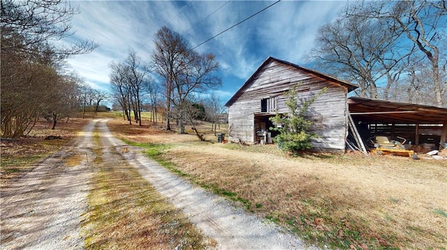 view of side of property featuring an outbuilding, driveway, and a barn